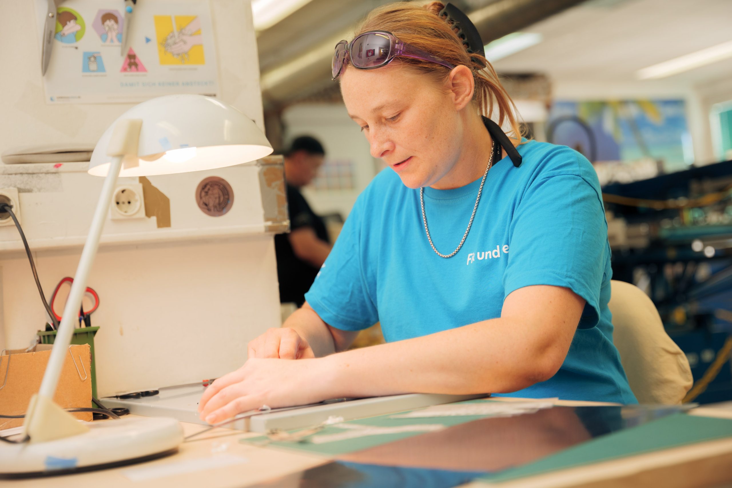 Textildruck-Mitarbeiterin am Arbeitstisch bereitet Druckvorlagen für Textilien vor